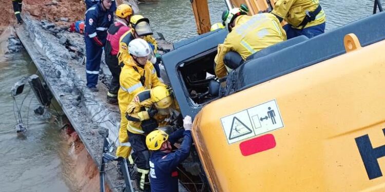Retroescavadeira fica pendurada em ponte e resgate do motorista dura nove horas